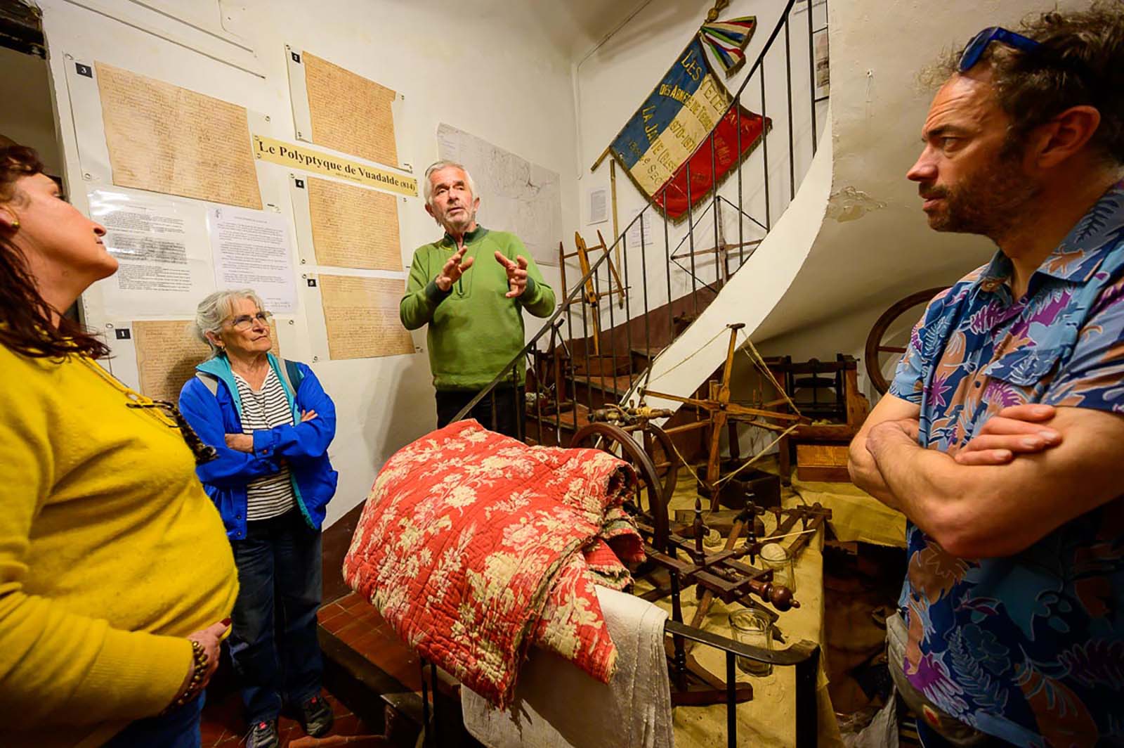 Salle de classe ancienne à l'Écomusée de la Javie avec visiteurs, objets scolaires d'époque et tableau noir